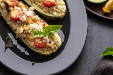 Kıyılmış et ile dolması kabak siyah bir zemin üzerine peynir. Fırında pişmiş. Kopya alanı.