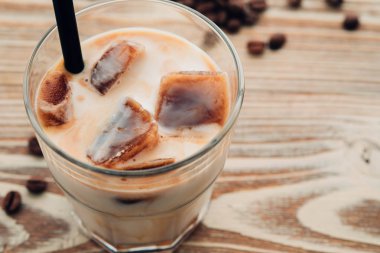 Soğuk kahve cam ahşap masa arka plan üzerinde buz küpleri ile. Buzlu kahve. Kopya alanı.