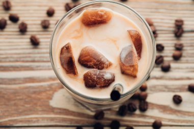 Soğuk kahve cam ahşap masa arka plan üzerinde buz küpleri ile. Buzlu kahve. Kopya alanı.