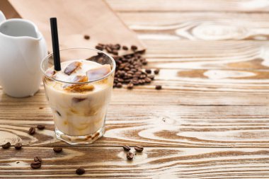 Soğuk kahve cam ahşap masa arka plan üzerinde buz küpleri ile. Buzlu kahve. Kopya alanı.