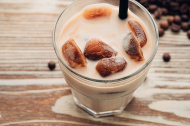 Soğuk kahve cam ahşap masa arka plan üzerinde buz küpleri ile. Buzlu kahve. Kopya alanı.