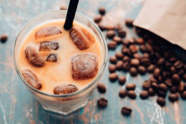 Soğuk kahve cam ahşap masa arka plan üzerinde buz küpleri ile. Buzlu kahve. Kopya alanı.