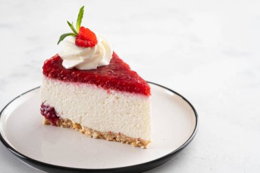 Taze ahududu ve beyaz tabakta nane yapraklı cheesecake dilimi. Boşluğu kopyala.