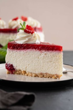 Taze ahududu ve beyaz tabakta nane yapraklı cheesecake dilimi. Boşluğu kopyala.