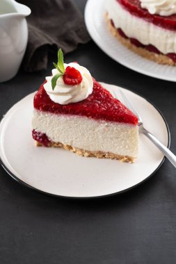 Taze ahududu ve beyaz tabakta nane yapraklı cheesecake dilimi. Boşluğu kopyala.
