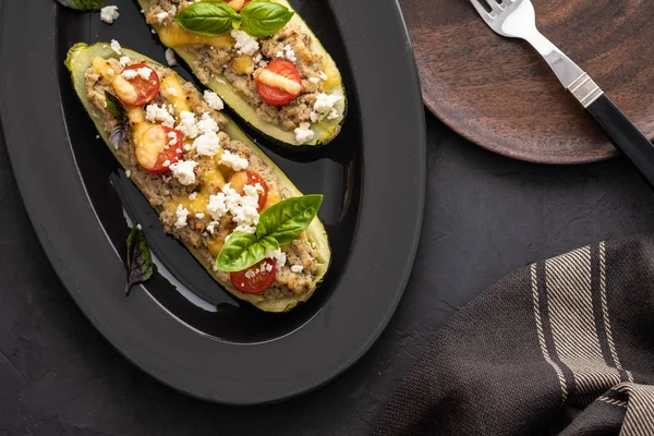 Kıyılmış et ile dolması kabak siyah bir zemin üzerine peynir. Fırında pişmiş. Kopya alanı.