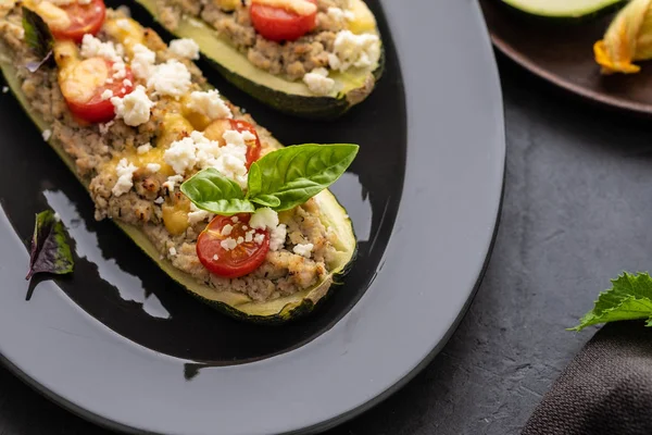 Kıyılmış et ile dolması kabak siyah bir zemin üzerine peynir. Fırında pişmiş. Kopya alanı.