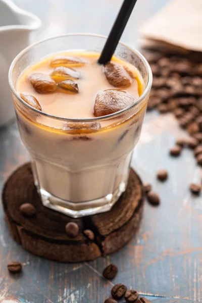 Soğuk kahve cam ahşap masa arka plan üzerinde buz küpleri ile. Buzlu kahve. Kopya alanı.