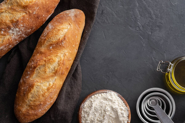 Fresh bread with ingredients on a dark background. Copy space.