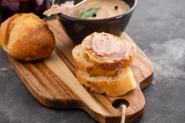 Ev yapımı tavuk karaciğer pate veya yapıştırma bir rustik ahşap tahta üzerinde ev yapımı ekmek ve kızılcık sosu ile servis.