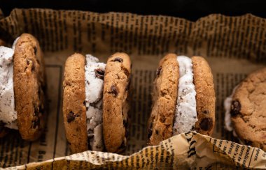 Kağıt arka plan üzerinde dondurma sandviç çikolatalı kurabiye ek yük vurdu.