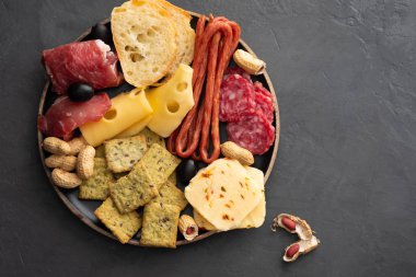 Et ve Peynir tabağı. Kesme füme kurula salam, soğuk et, salam, jambon, peynir, zeytin, siyah arka plan üzerine Kapari geleneksel İtalyan meze. Peynir ve et iştah açıcı. Üstten Görünüm.