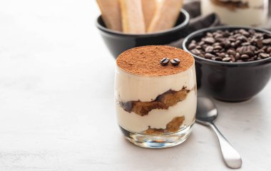 Bir bardak beyaz taş zemin üzerine geleneksel İtalyan tatlı tiramisu. Kopya alanı.