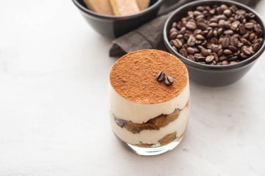 Bir bardak beyaz taş zemin üzerine geleneksel İtalyan tatlı tiramisu. Kopya alanı.