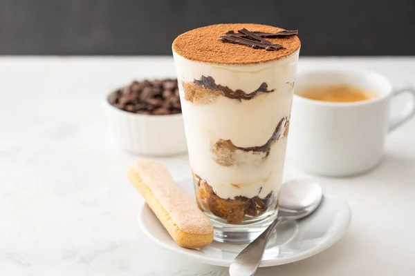 Tiramisu dalam gelas dengan biji kopi di latar belakang putih. Salin ruang . — Stok Foto