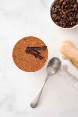 Bir bardak beyaz zemin üzerine kahve çekirdekleri ile tiramisu. Uzay kopyalayın. Üstten görünüm.