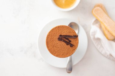 Bir bardak beyaz zemin üzerine kahve çekirdekleri ile tiramisu. Uzay kopyalayın. Üstten görünüm.