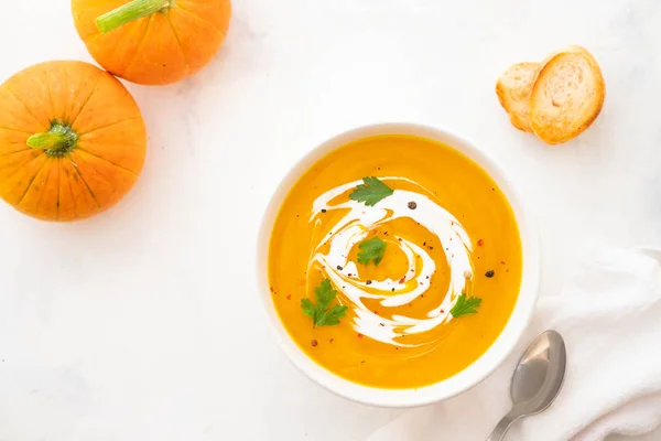 Тыквенный суп со сливками и семян тыквы изолированы на белом фоне. Осенняя концепция . — стоковое фото
