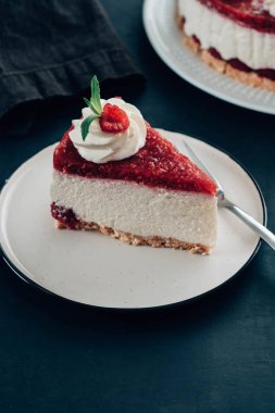 Ahududulu tart, mus kek, cheesecake taze ahududu ile. Parçası cheesecake beyaz bir plaka üzerinde.