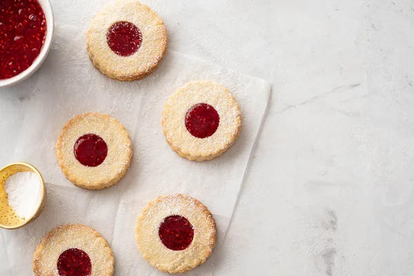 Galletas de Navidad. Galletas Linzer con mermelada de frambuesa sobre fondo de mesa blanco. Galletas tradicionales austriacas rellenas. Vista superior y espacio de copia — Foto de Stock