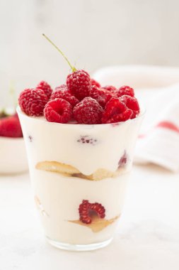 Ahududu tatlı, cheesecake, ahududulu tiramisu, önemsememek, mus bir bardak beyaz bir arka plan üzerinde.