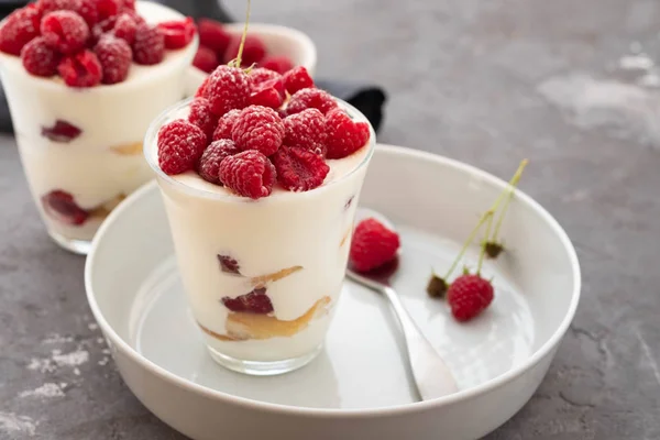 Tiramisu avec framboise dans des verres sur fond gris. Dessert italien. Espace de copie . — Photo