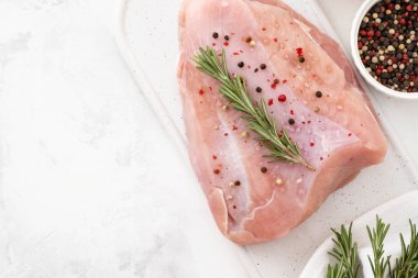 Ham Türkiye göğüs fileto otlar ile ahşap kesme tahtası üzerinde tablo üzerinde baharat beyaz. kopya alanı ile üstten görünüm