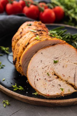 Siyah bir arka plan üzerinde hindi göğsü pişmiş sebze ve baharatlar ile doldurulmuş.