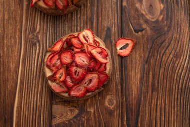 Kurutulmuş çilek ahşap arka plan üzerinde bir kasede. Yaz konsepti. Kopya alanı.