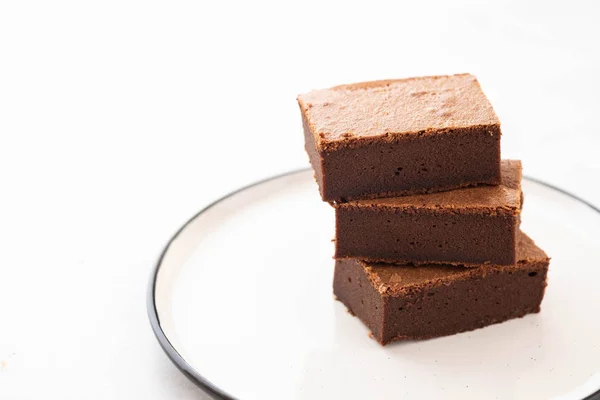 Chocolate brownie piezas cuadradas en la pila en el plato blanco. Postre americano tradicional delicioso. Copiar espacio . — Foto de Stock