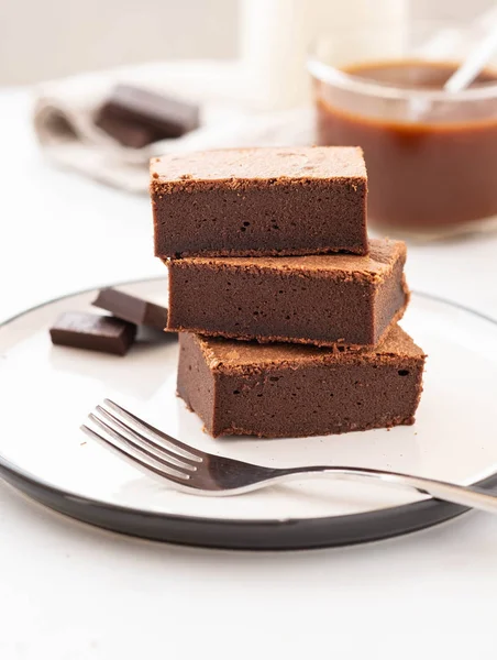 Chocolate brownie piezas cuadradas en la pila en el plato blanco. Postre americano tradicional delicioso. Copiar espacio . — Foto de Stock