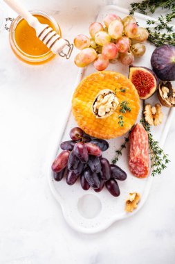 Peynir tabağı üzüm, reçeli, incir, kraker ve beyaz zemin üzerine fındık ile devam eder. Kopya alanı.