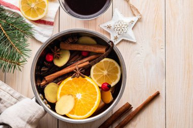 Narenciye, elma ve baharat alüminyum tencere ve köknar dalı arka plan üzerinde mulled şarap sıcak içecek.