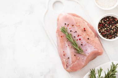 Ham Türkiye göğüs fileto otlar ile ahşap kesme tahtası üzerinde tablo üzerinde baharat beyaz. kopya alanı ile üstten görünüm