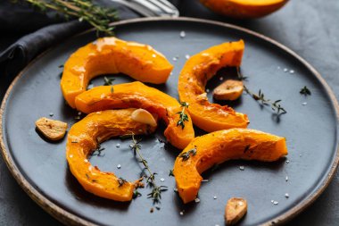 Sarımsak ve biberiye siyah bir plaka üzerinde pişmiş kabak taşlarla. Kopya spase.