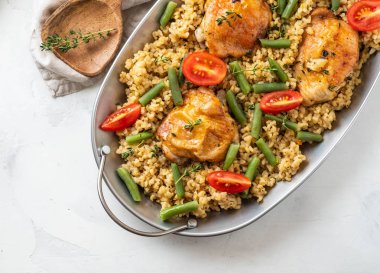 Bulgur, fasulye kuşkonmaz ve domates ile ızgara tavuk uyluk. Lezzetli yemegi.