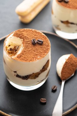 Lezzetli İtalyan tatlı tiramisu, çikolata, kakao ve kahve fasulye siyah bir arka plan. Kopya alanı.