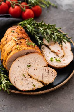 Siyah bir arka plan üzerinde hindi göğsü pişmiş sebze ve baharatlar ile doldurulmuş.