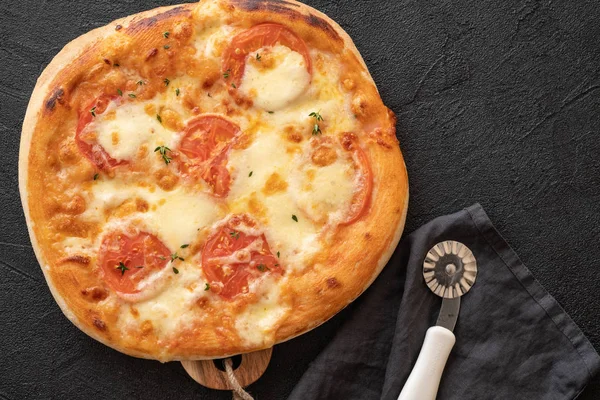 Pizza Margherita op zwarte stenen achtergrond. Zelfgemaakte Pizza Margarita met tomaten en Mozzarella Kaas. — Stockfoto