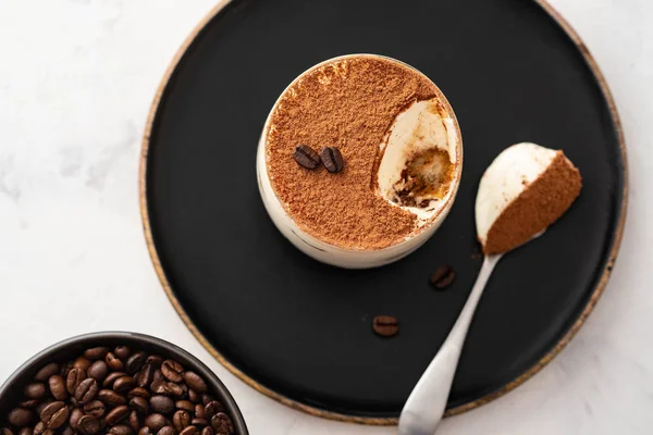Lezzetli İtalyan tatlı tiramisu, çikolata, kakao ve kahve fasulye siyah bir arka plan. Kopya alanı.