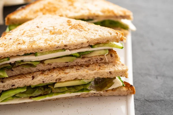 Sándwich vegetariano saludable con rúcula, lechuga y aguacate, mostaza, pepino. Primer plano. Alimento saludable . —  Fotos de Stock