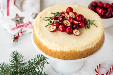 Cheescake taze kızılcık ve biberiye ile. Noel kek dekorasyonu beyaz arka plan üzerinde ile.