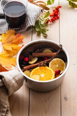Narenciye, elma ve baharat alüminyum tencere ve köknar dalı arka plan üzerinde mulled şarap sıcak içecek.