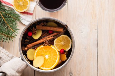 Narenciye, elma ve baharat alüminyum tencere ve köknar dalı arka plan üzerinde mulled şarap sıcak içecek.