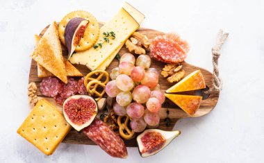 Üzüm, reçeli, incir, kraker ve bir arka plan üzerinde fındık ile peynir tabağı servis.