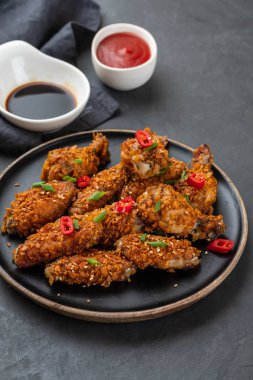 Tavuk kanadı sosu ve karanlık bir arka plan üzerine biber ile. Kopya alanı.