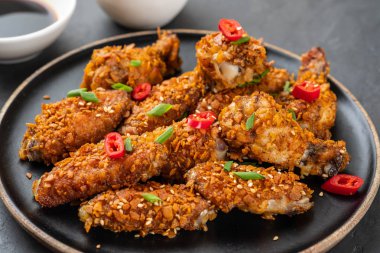 Tavuk kanadı sosu ve karanlık bir arka plan üzerine biber ile. Kopya alanı.