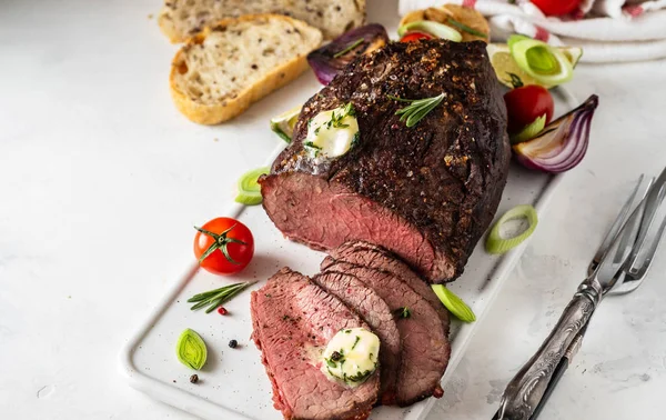 Carne asada con salsa y tenedor de carne sobre fondo blanco. Copiar espacio . —  Fotos de Stock