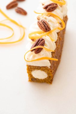 Beyaz mermer üzerinde krem rengi havuç havuç kek pasta ile fındık, serpilir, süslenmiş.