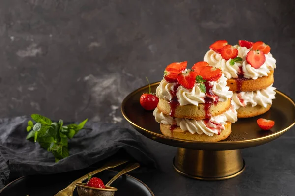 Pastel de esponja Victoria con fresas, mermelada y crema batida sobre fondo oscuro. Copiar espacio . — Foto de Stock